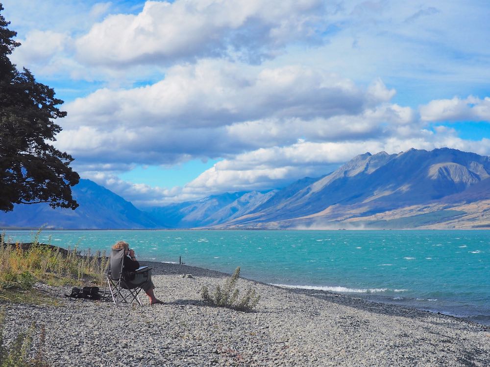 Nicky sitting in a camp chair on Lake Ohau beach