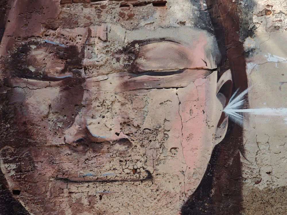 Getsemani street art - face with eyes shut