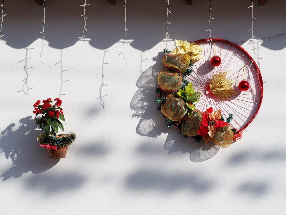 Two Christmas decorations on a whitewashed wall