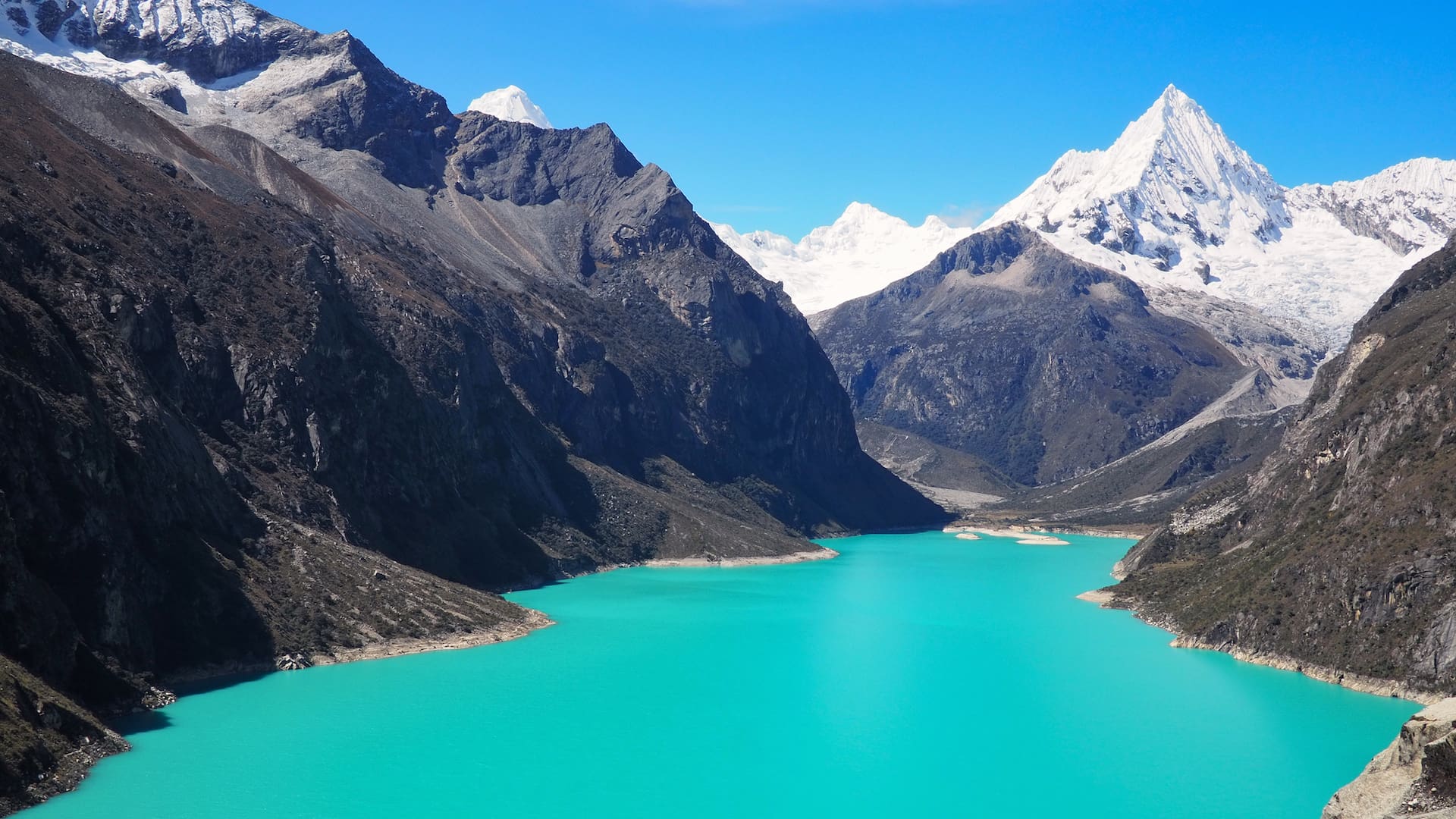 Turquoise lake in the foreground, snowy mountains in the background