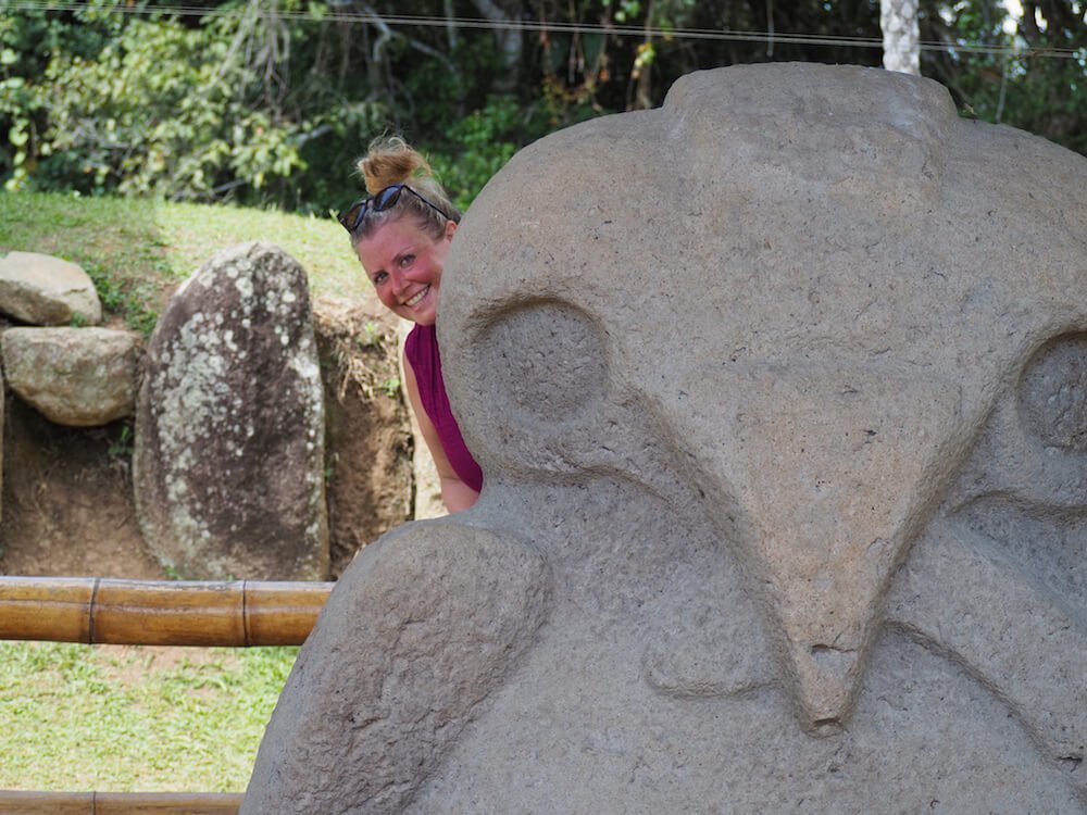Nicky peers from behind a statue in San Agustin Archaeological Park