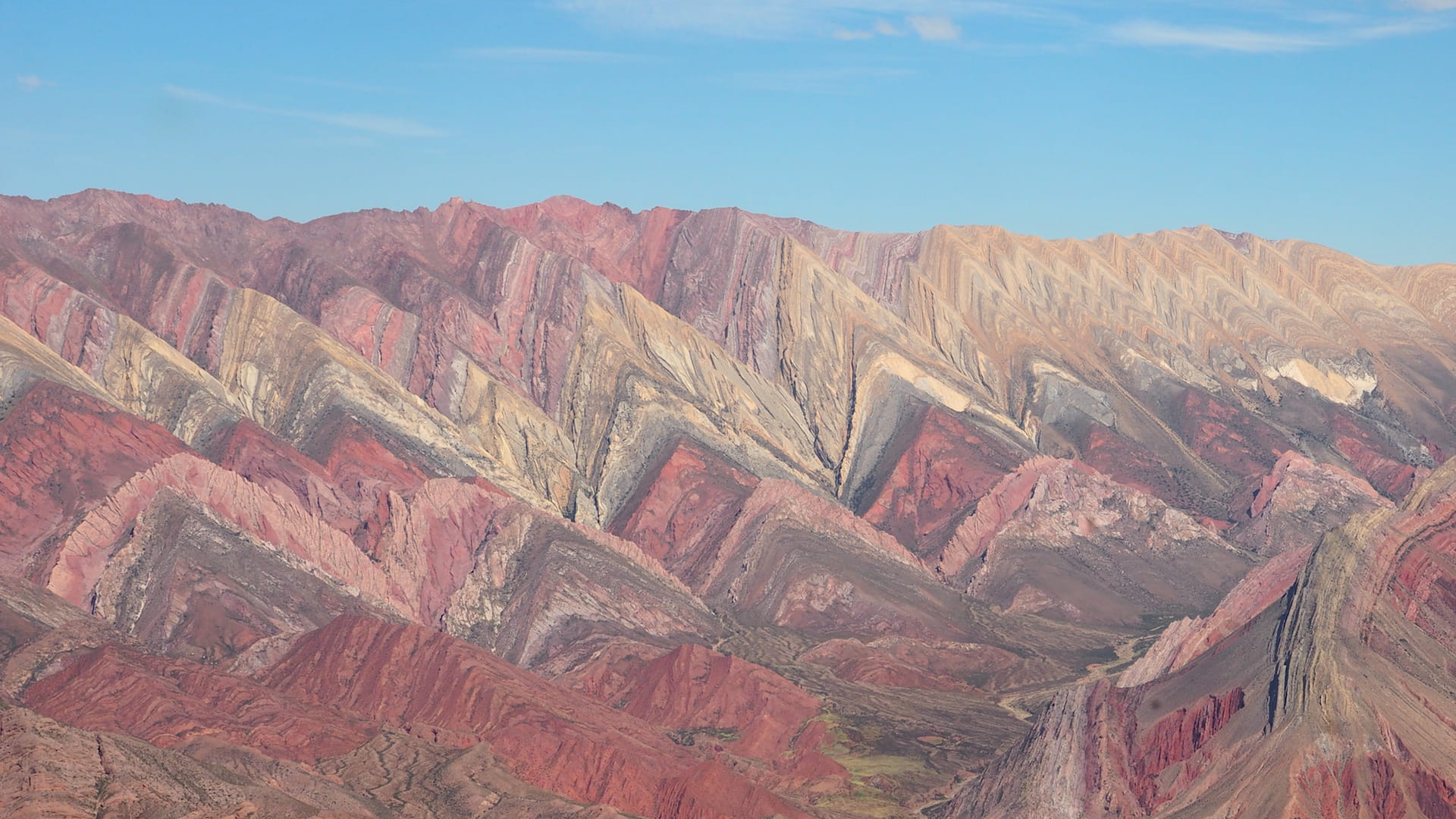 Mountainside with pink, cream and grey colourings in the shape of sharks' teeth
