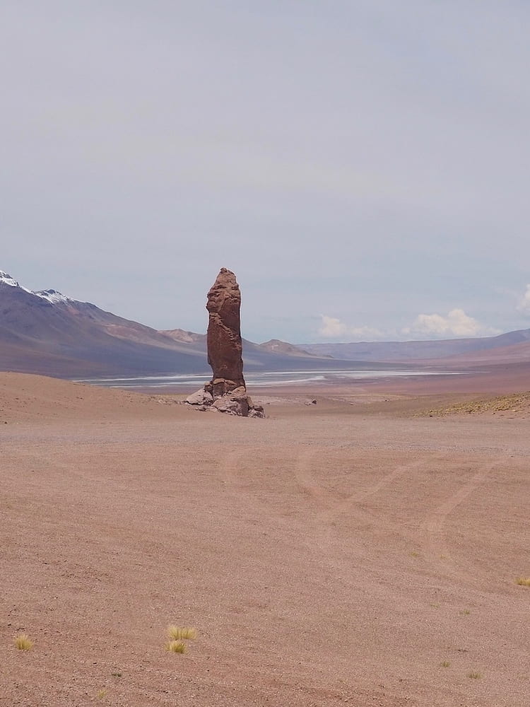 A single monolithic rock stands alone in the desert