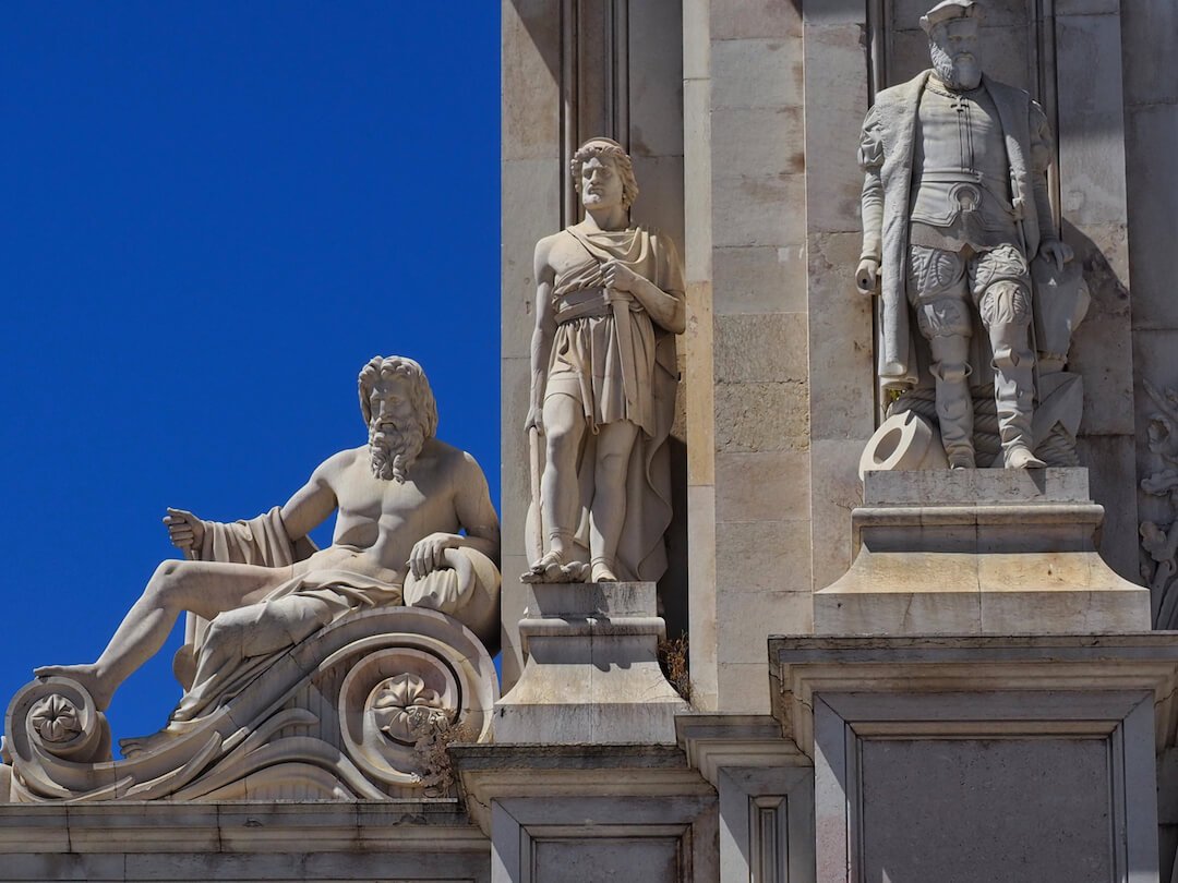 A close-up of three statues on a stone building