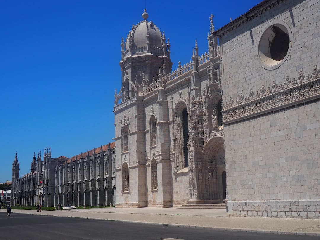A large white gothic building stretches from foreground to background