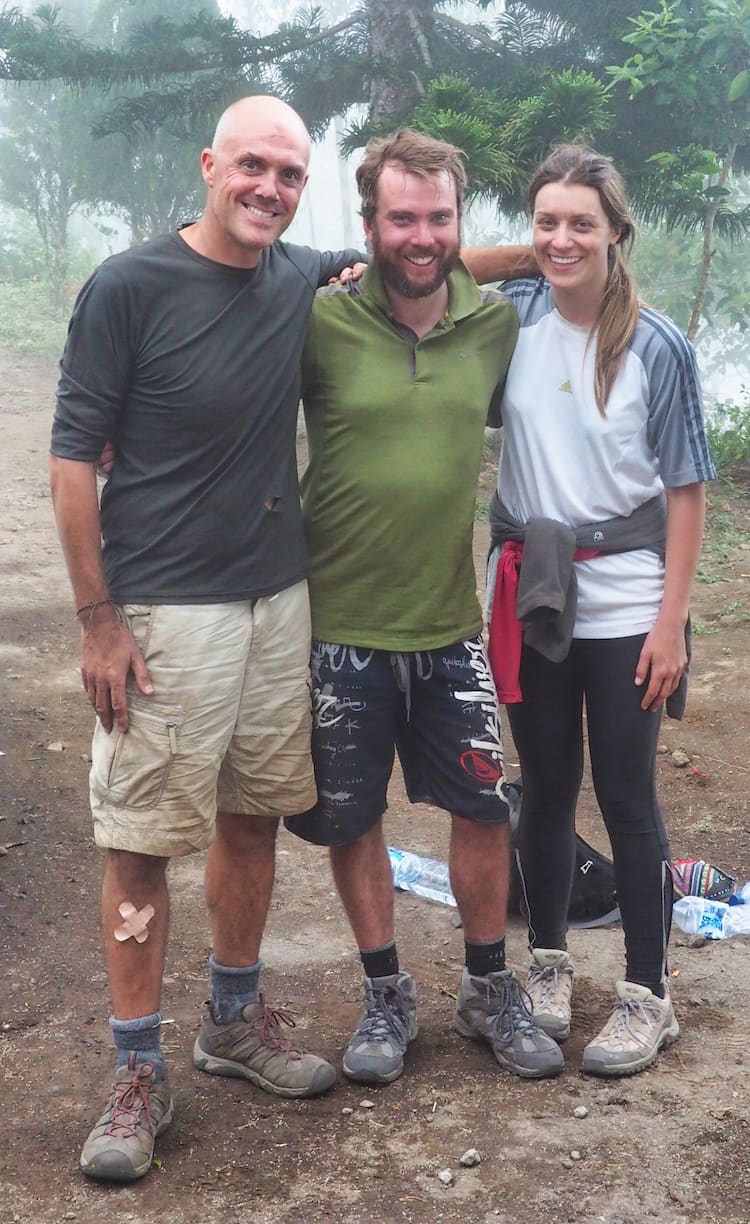 Three people pose for the camera at the end of a long hike