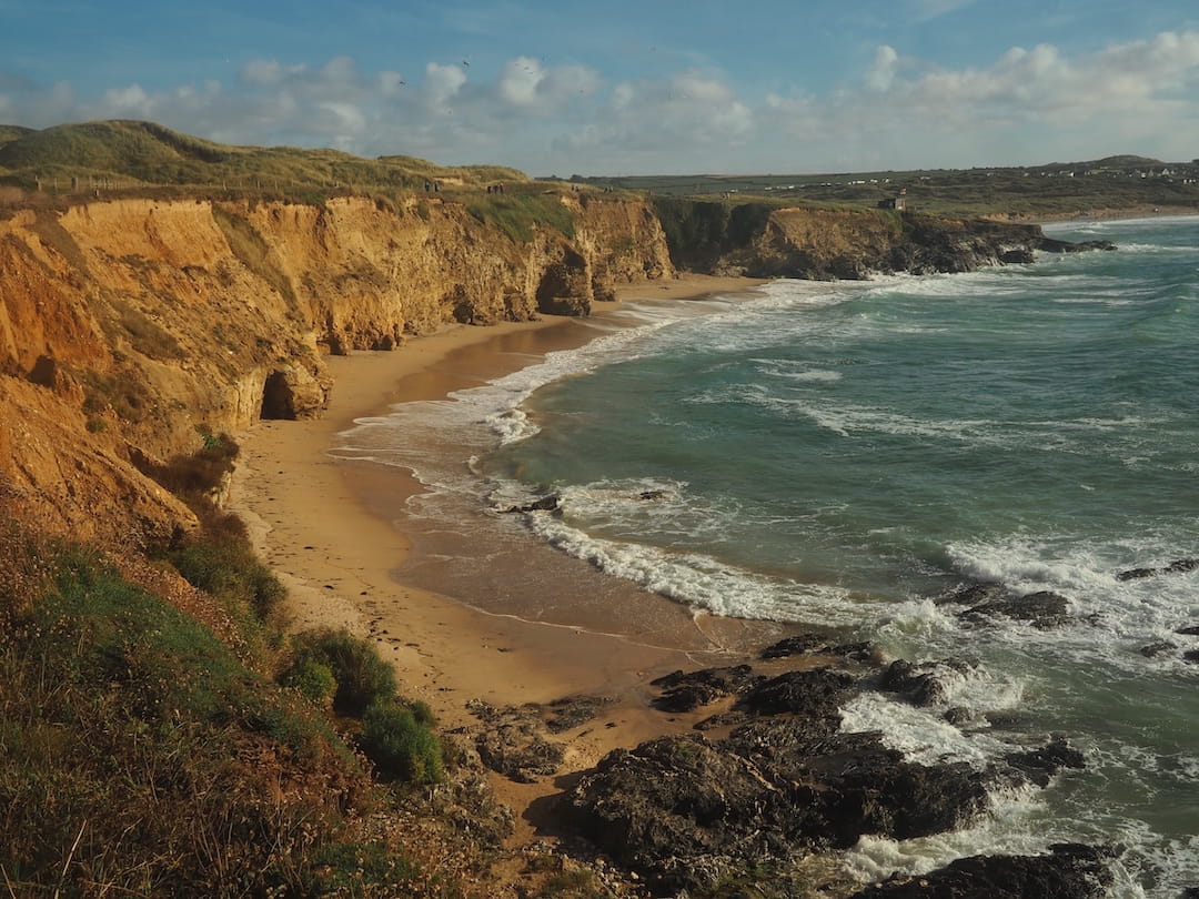 A horseshoe-shaped golden beach is backed by golden cliffs 
