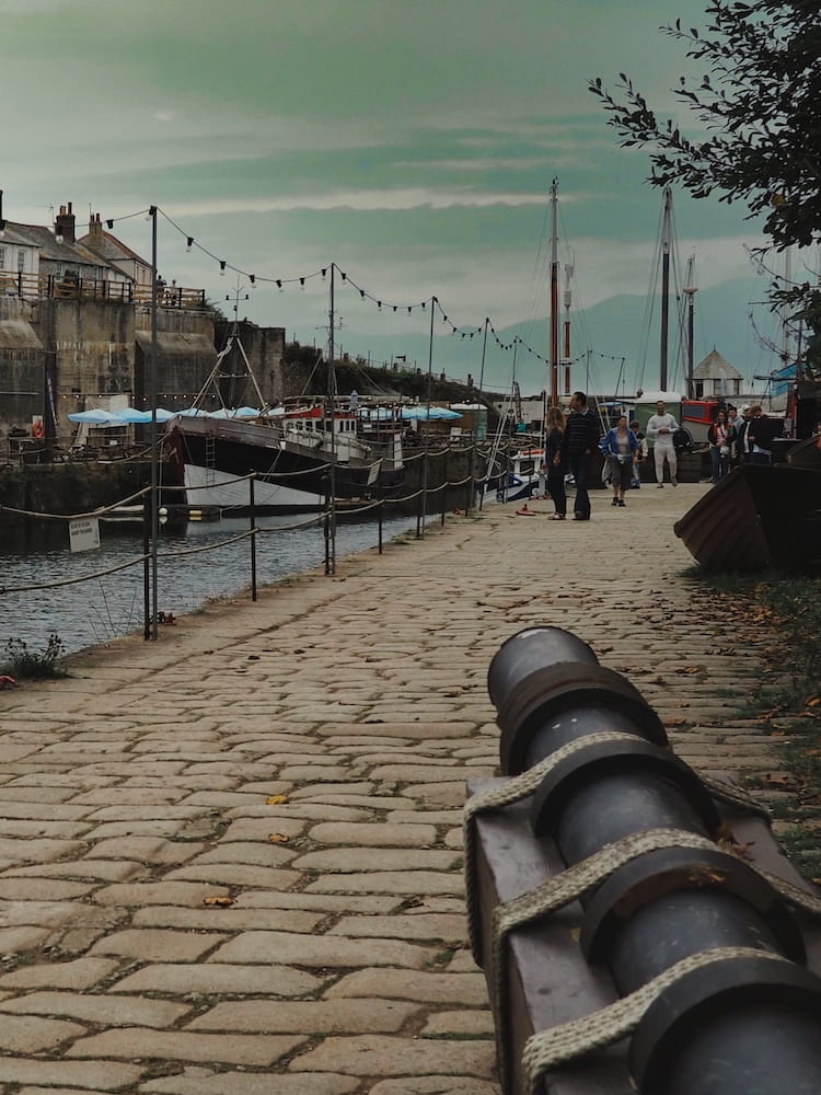 A cannon points beyond the harbour at Charlestown, Cornwall