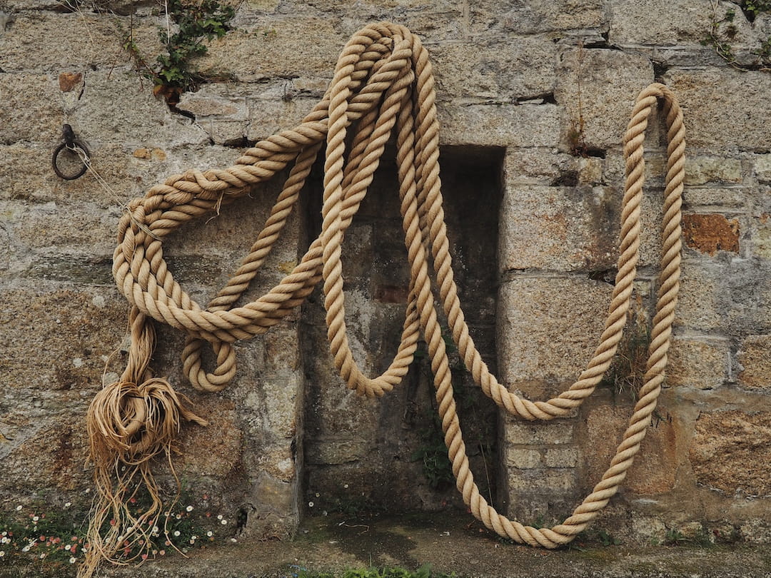 A rope hangs on the stone wall of Charlestown harbour