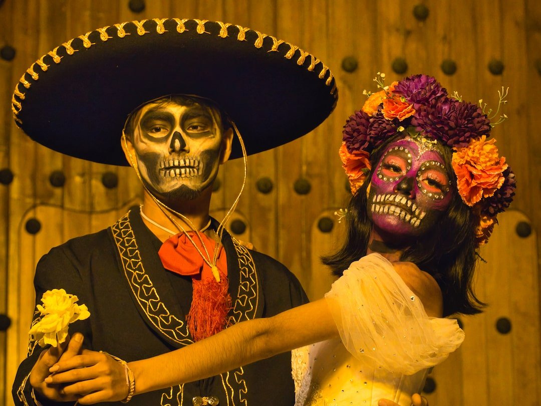 A man and a woman dress as catrinas for Day of the Dead