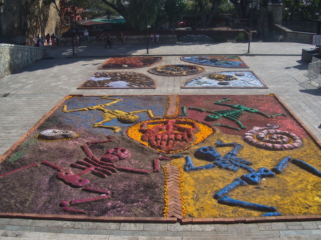 A square of sand art featuring figures in various colours